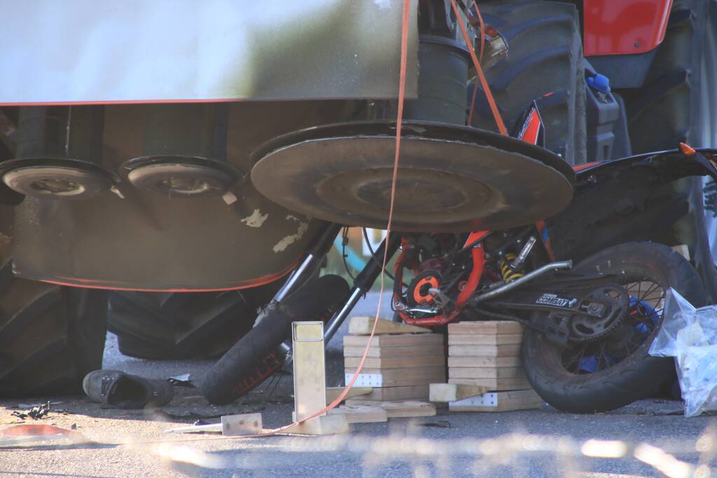 Scooter en scooterrijder bekneld onder tractor na ongeval