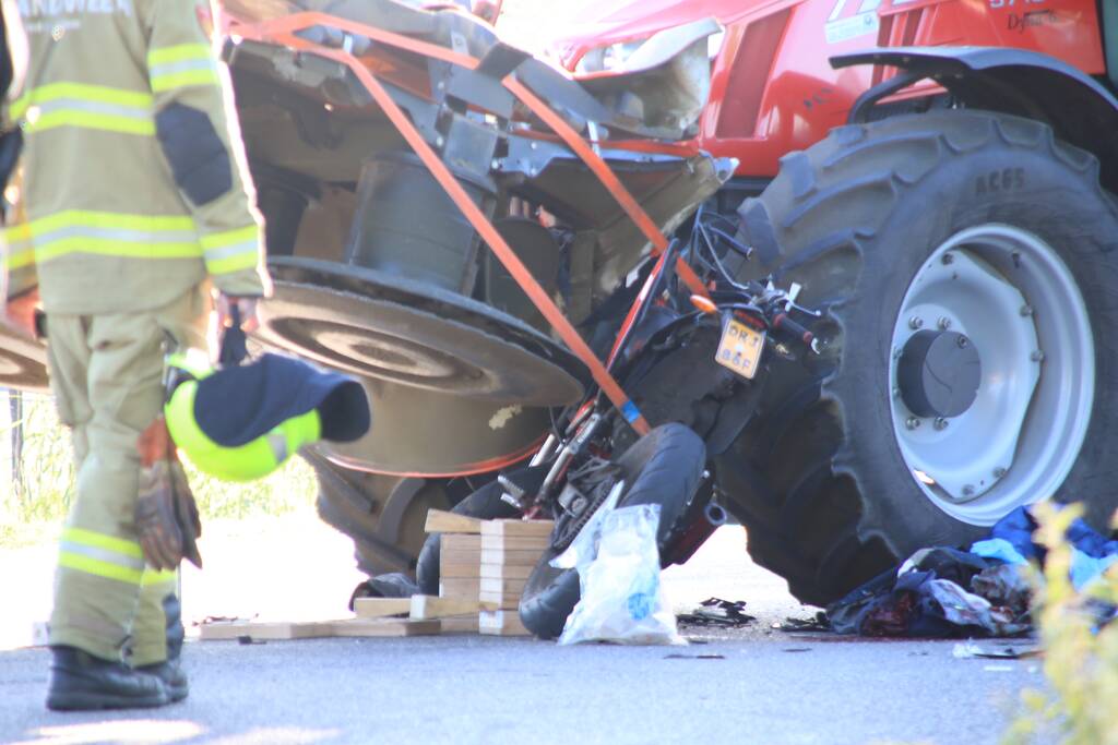 Scooter en scooterrijder bekneld onder tractor na ongeval