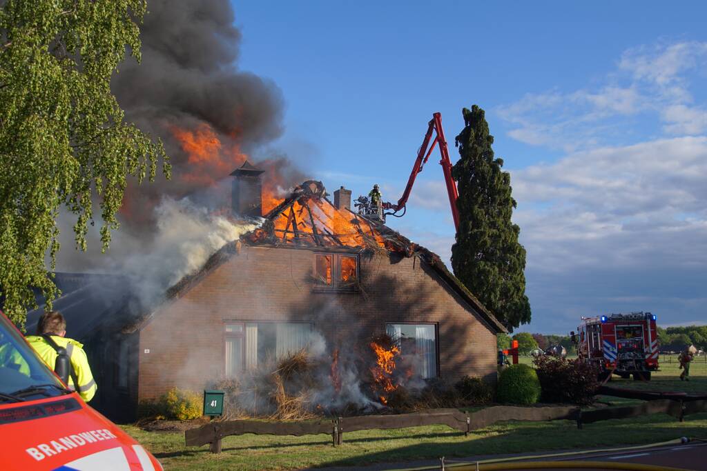 Rieten dak van woning volledig in brand