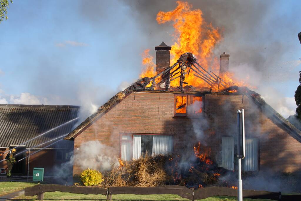 Rieten dak van woning volledig in brand