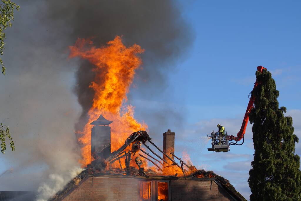 Rieten dak van woning volledig in brand