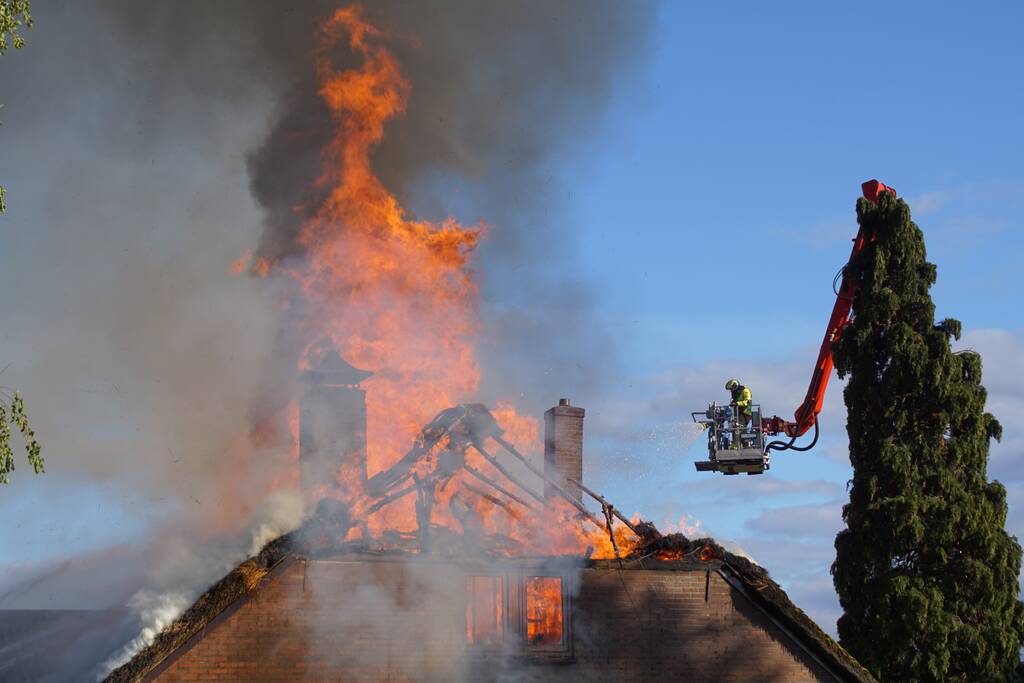 Rieten dak van woning volledig in brand