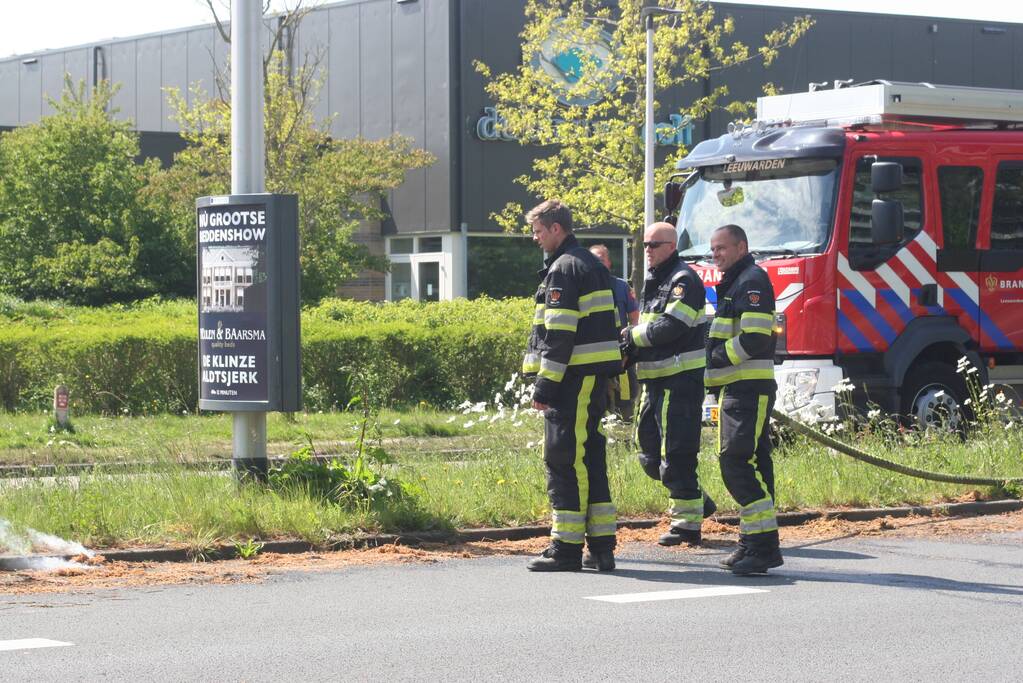Brandweer blust brandend gras in berm