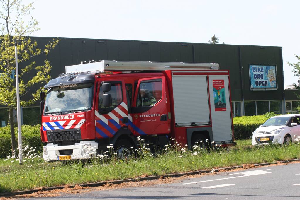 Brandweer blust brandend gras in berm