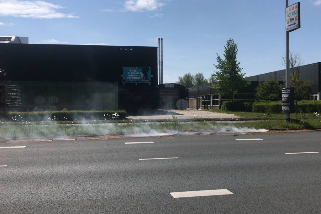 Brandweer blust brandend gras in berm