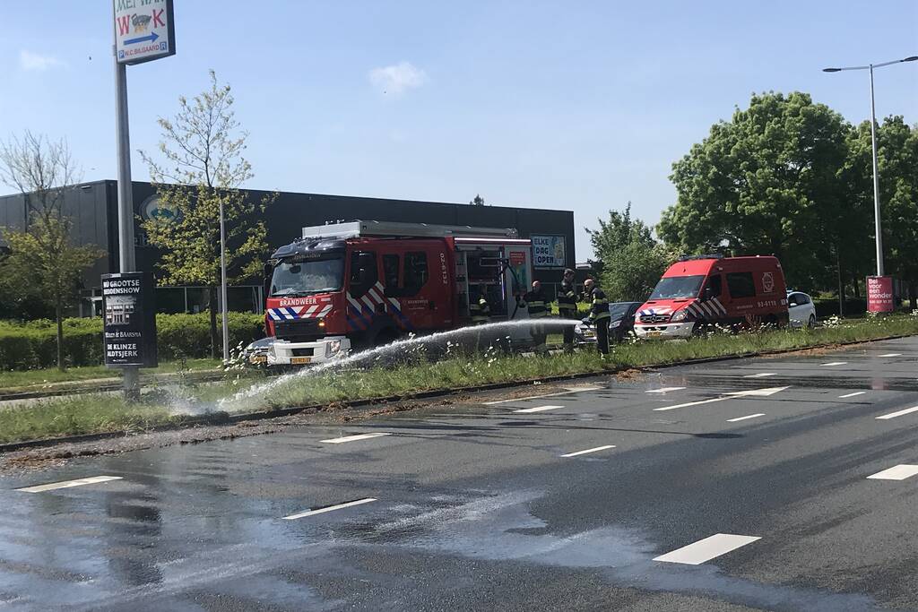 Brandweer blust brandend gras in berm