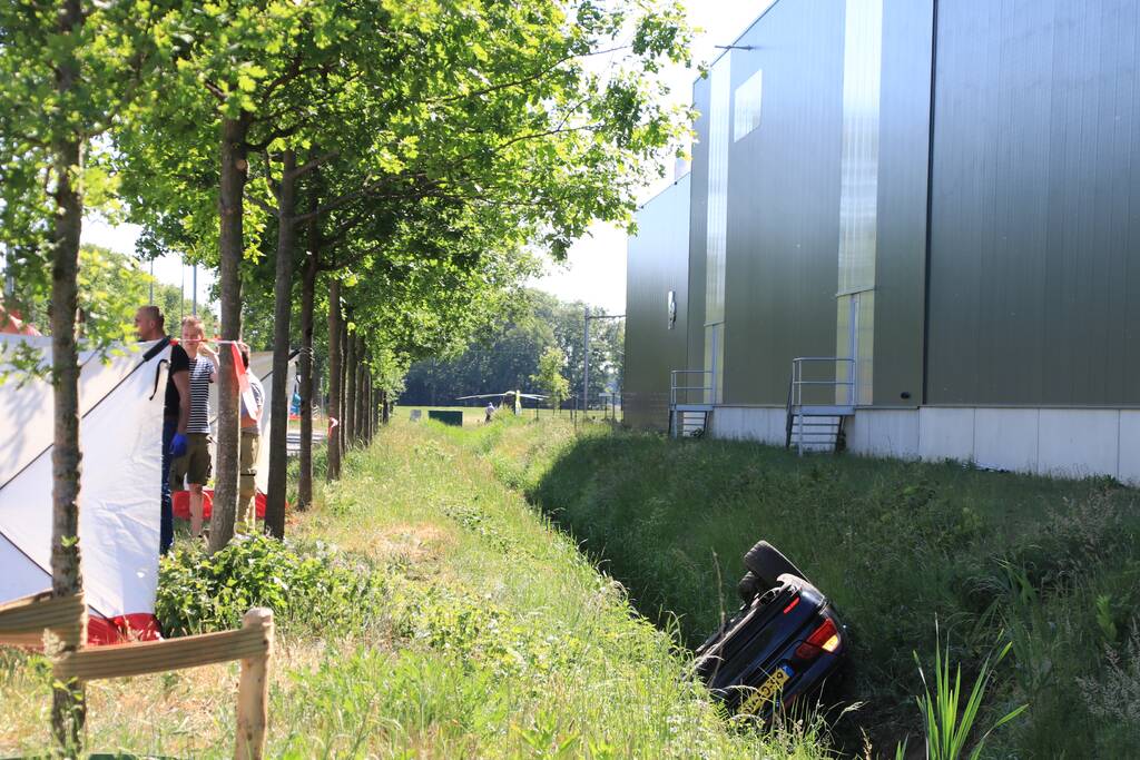 Auto belandt op de kop in de sloot, twee personen zwaargewond