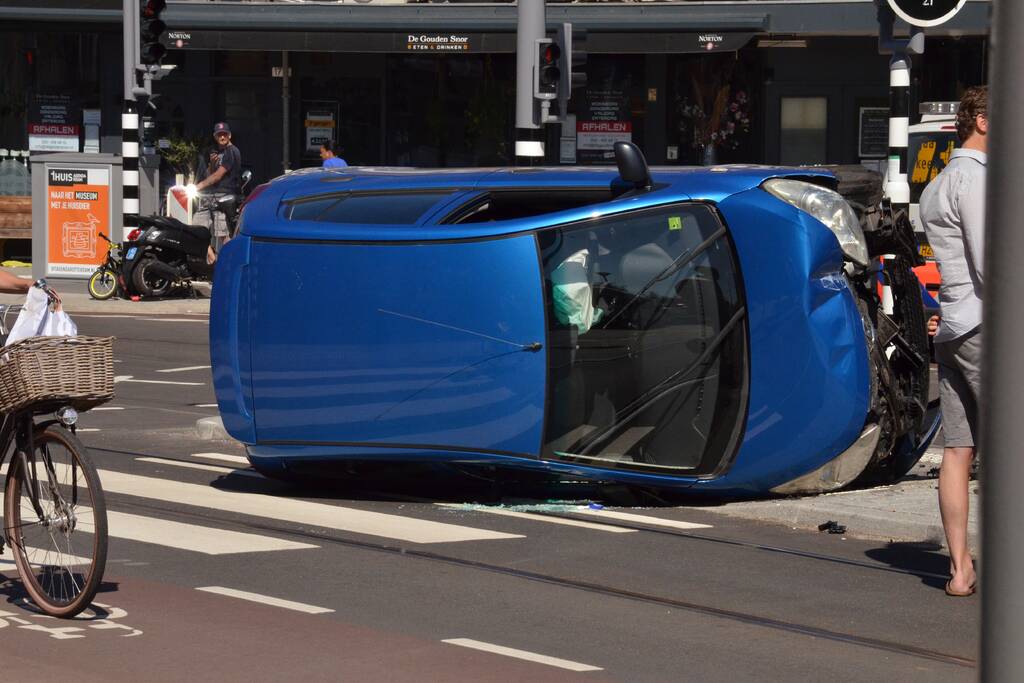 Auto crasht en belandt op zijn kant