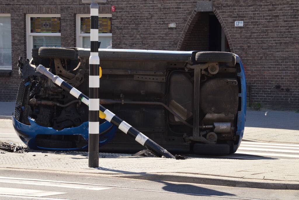 Auto crasht en belandt op zijn kant