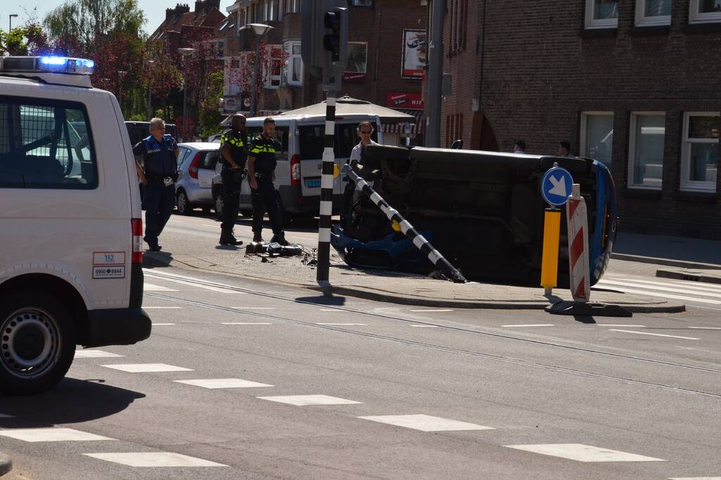 Auto crasht en belandt op zijn kant