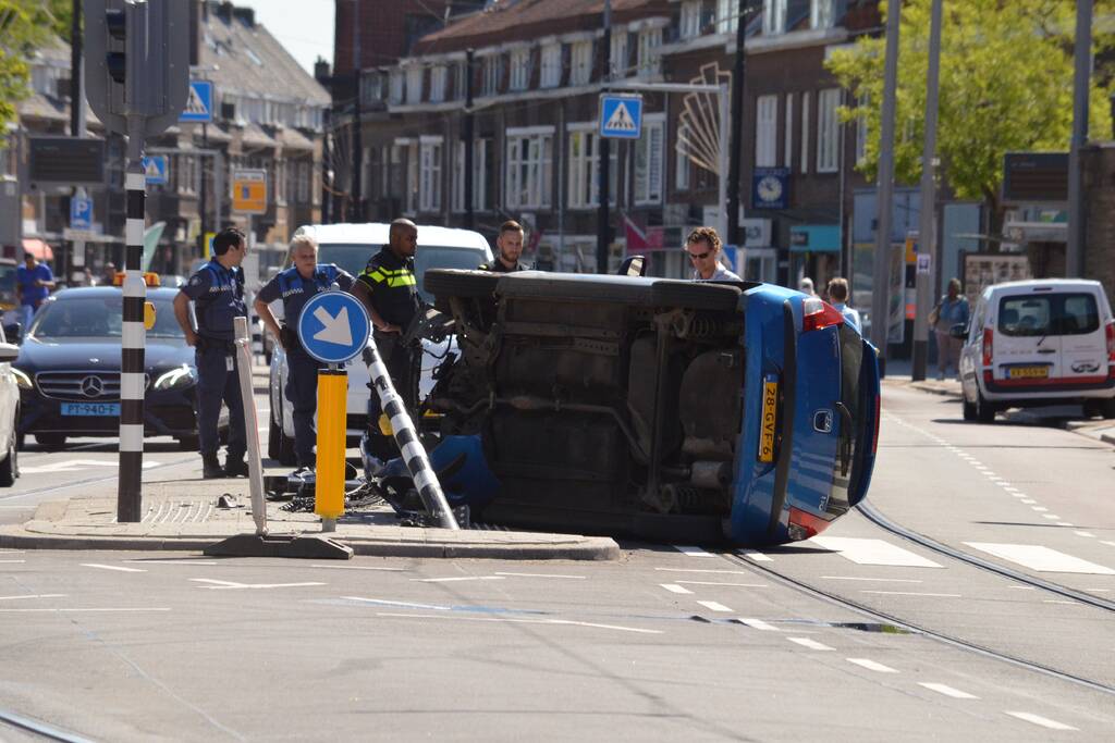 Auto crasht en belandt op zijn kant