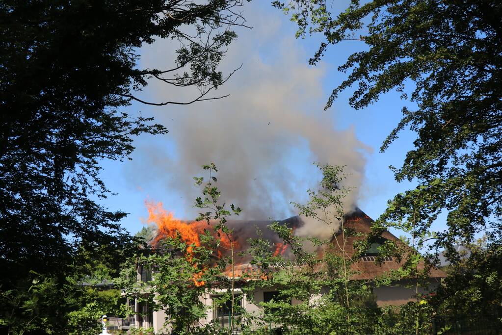 Uitslaande brand in rietendak van woning