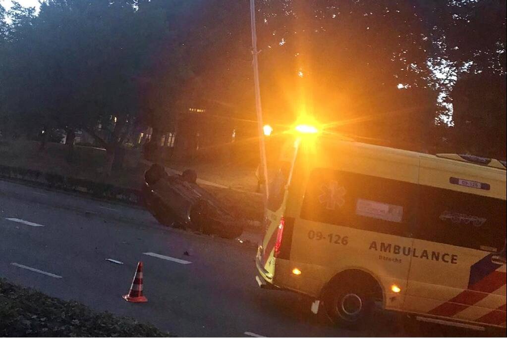 Auto knalt op lantaarnpaal en belandt op de kop