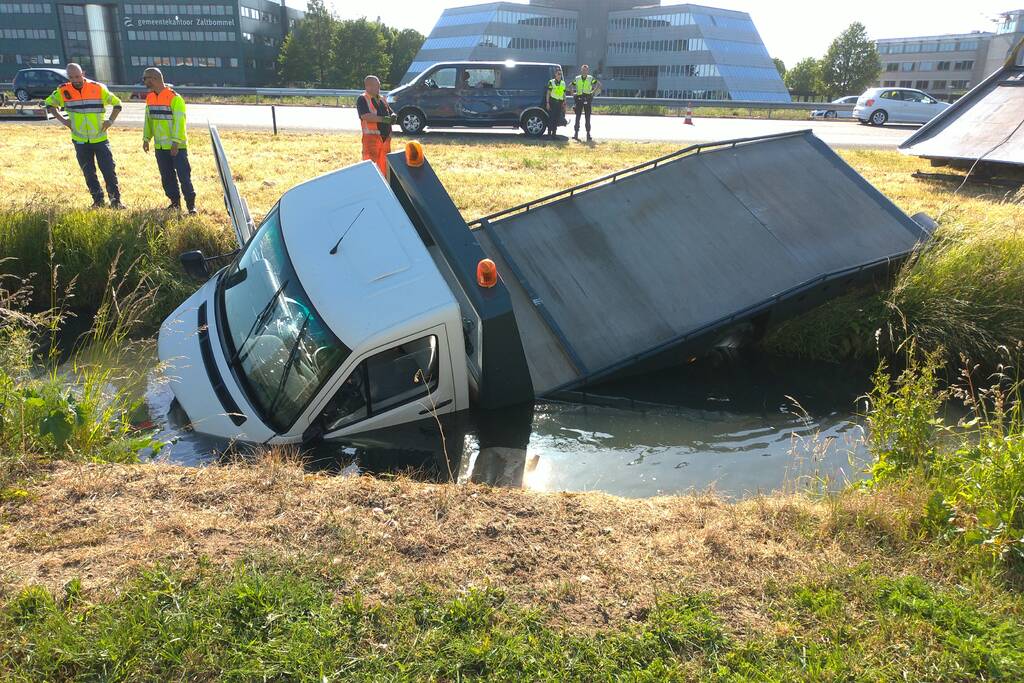 Bestelbus op zijn kant autoambulance in de sloot
