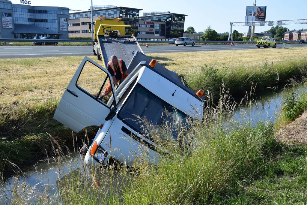 Bestelbus op zijn kant autoambulance in de sloot