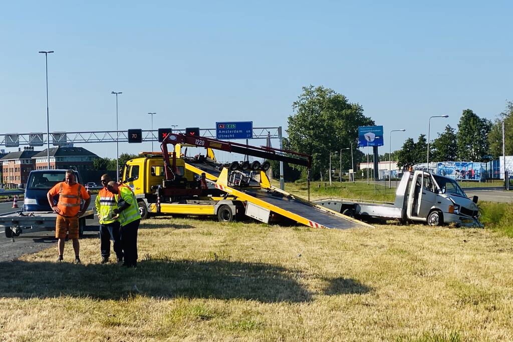 Bestelbus op zijn kant autoambulance in de sloot