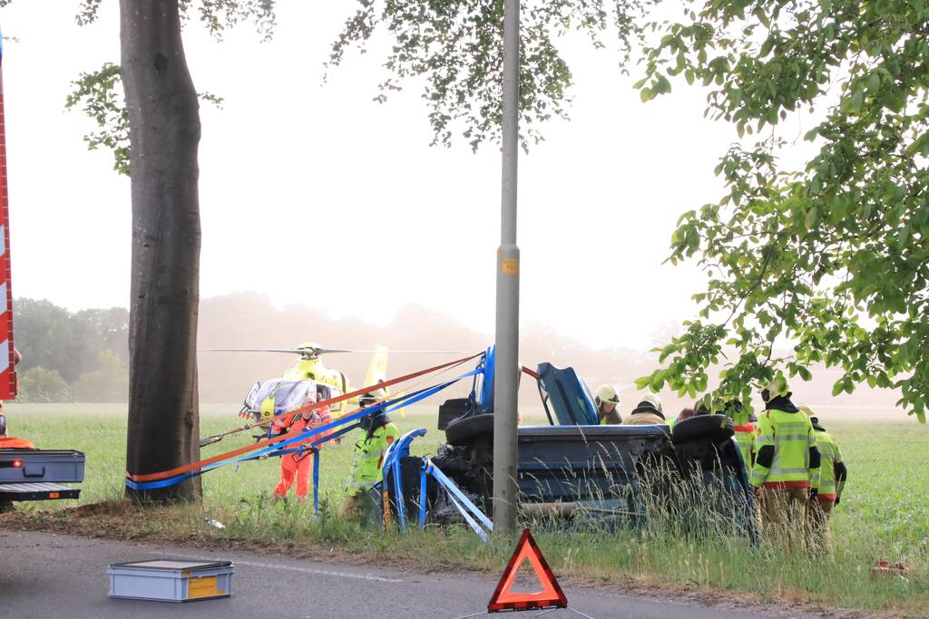 Auto belandt op zijn kant in weiland