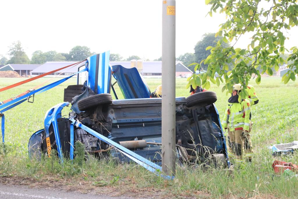 Auto belandt op zijn kant in weiland
