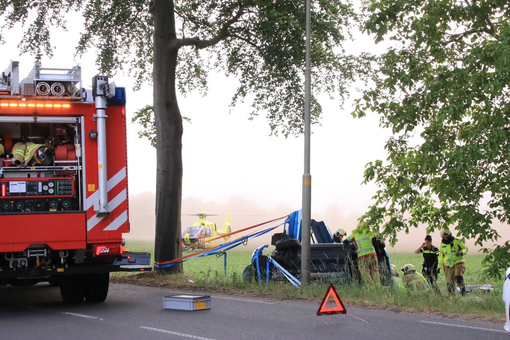 Auto belandt op zijn kant in weiland