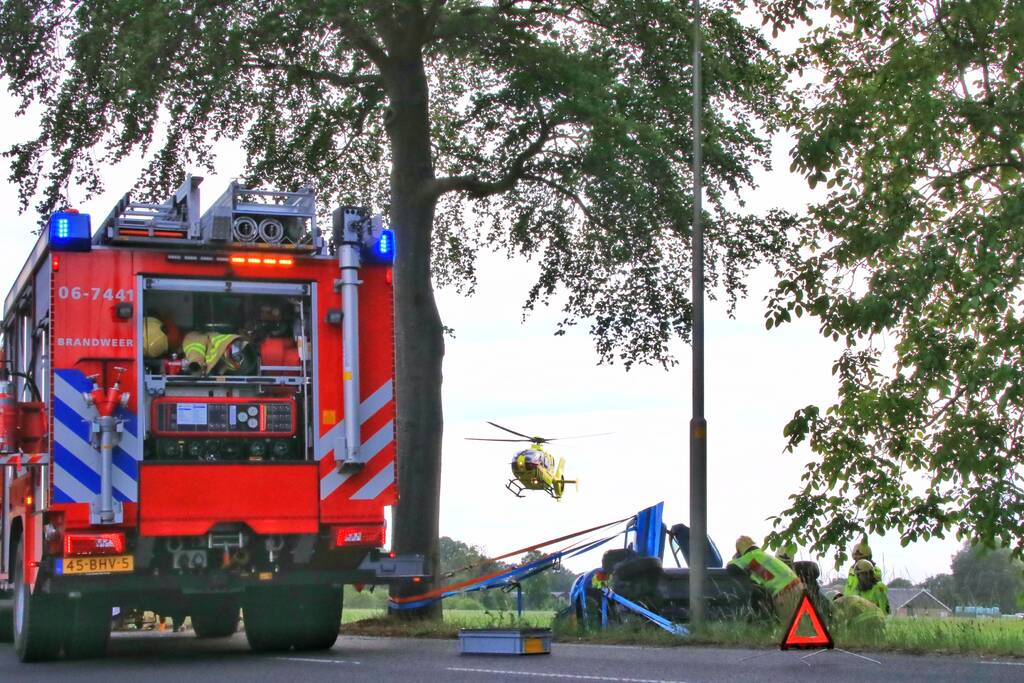 Auto belandt op zijn kant in weiland