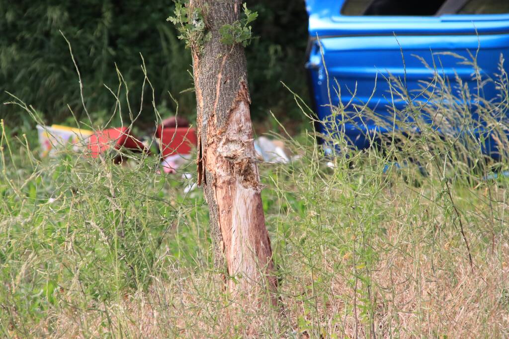 Auto belandt op zijn kant in weiland