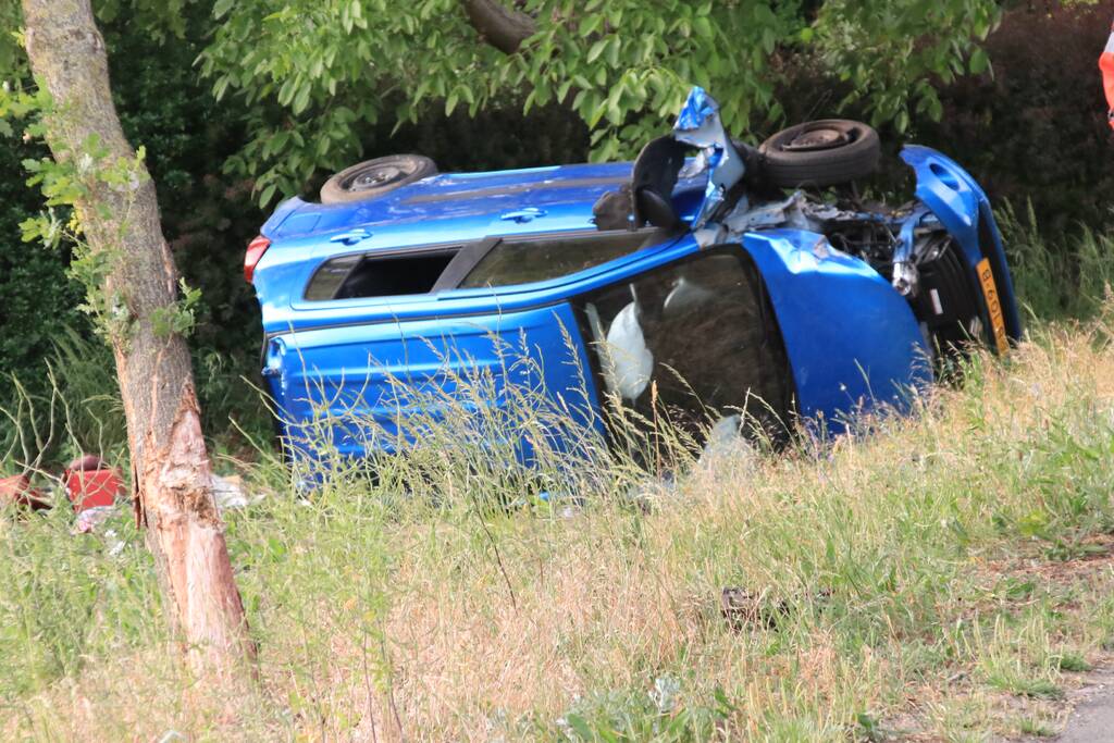 Auto belandt op zijn kant in weiland