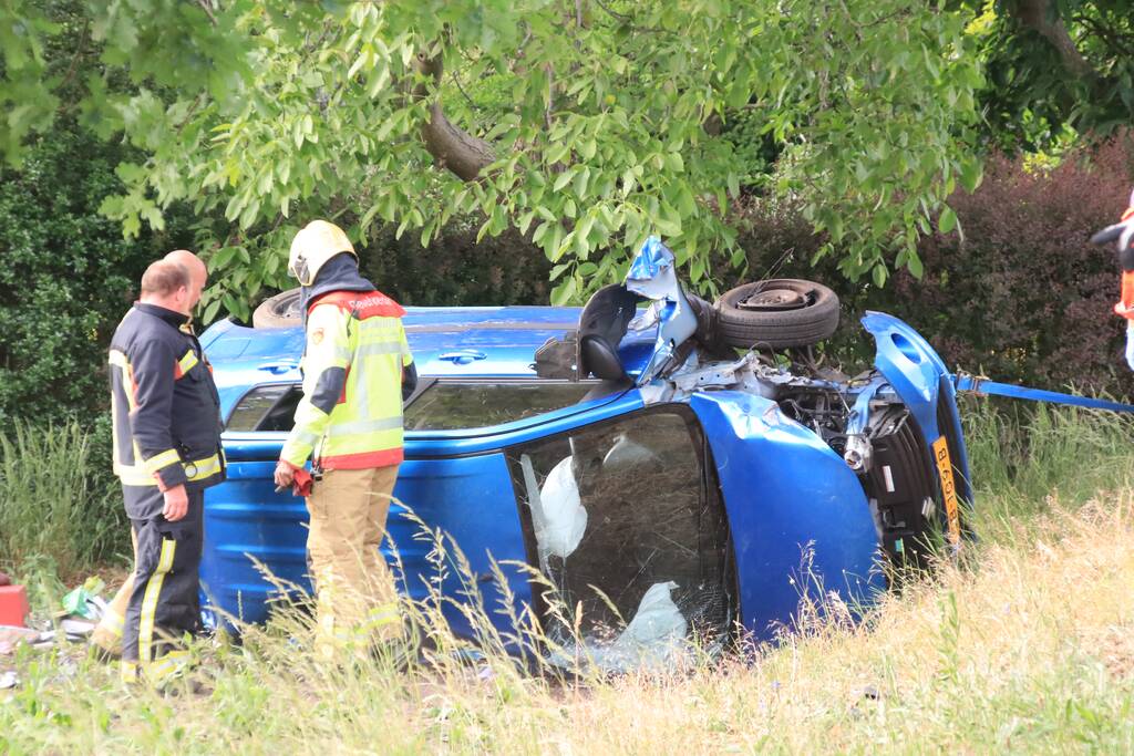 Auto belandt op zijn kant in weiland