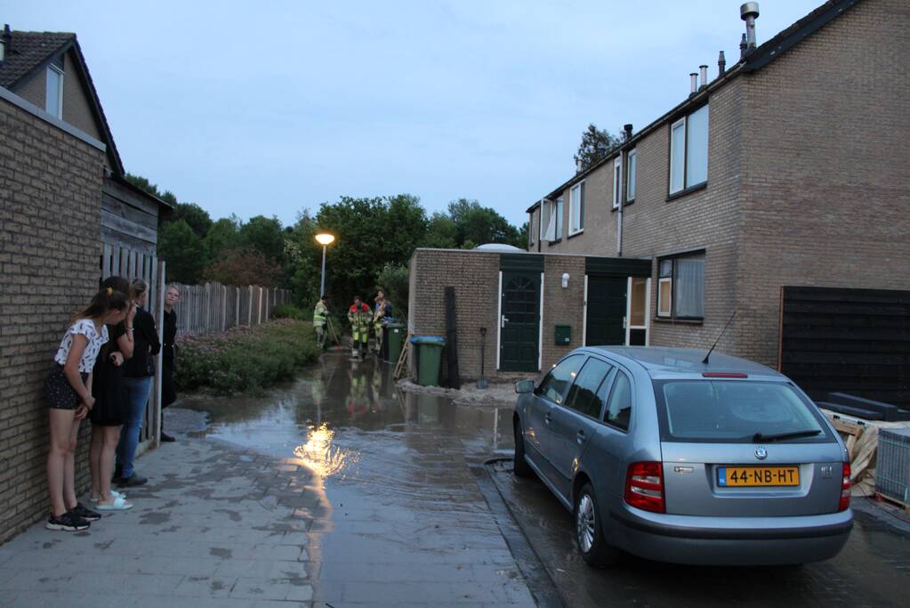 Groot sinkhole en straat vol water na leidingbreuk