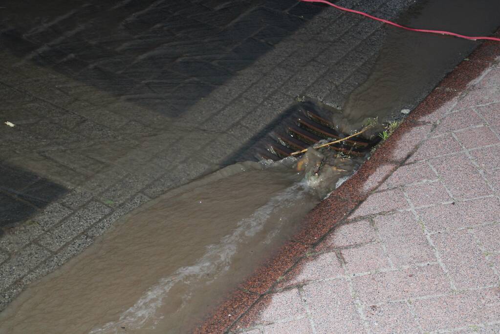 Groot sinkhole en straat vol water na leidingbreuk