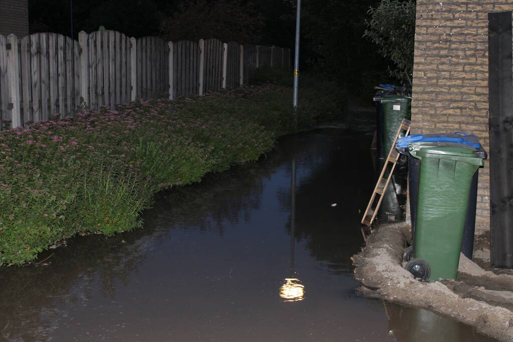 Groot sinkhole en straat vol water na leidingbreuk
