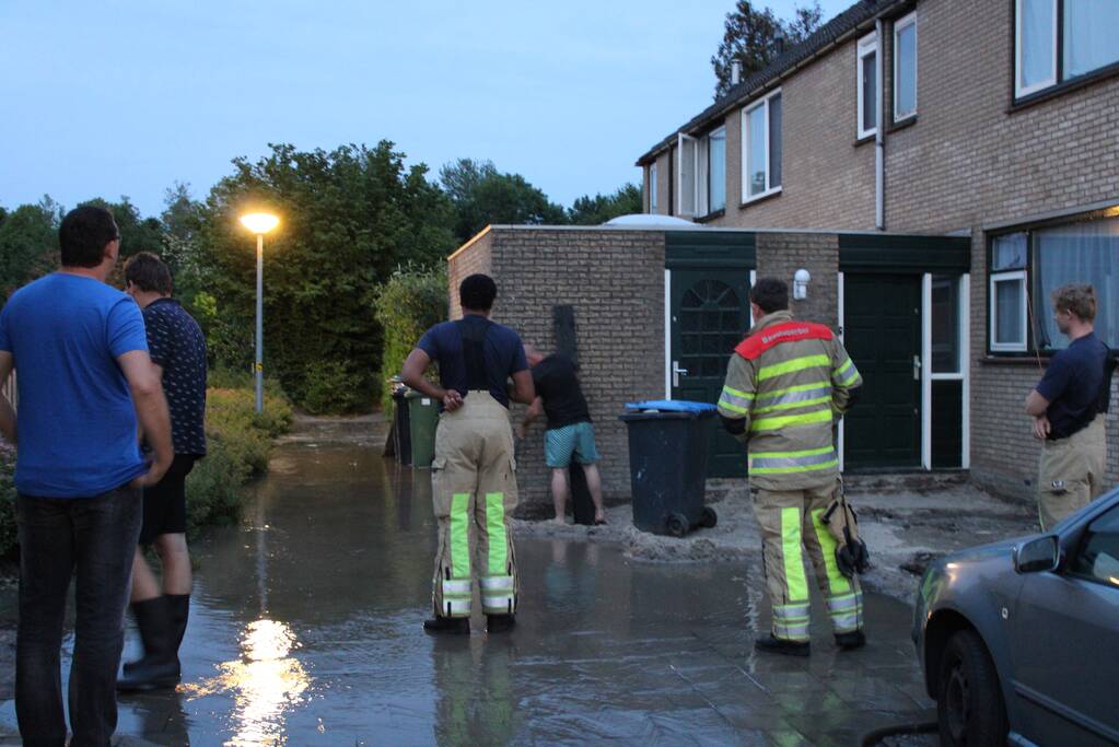 Groot sinkhole en straat vol water na leidingbreuk