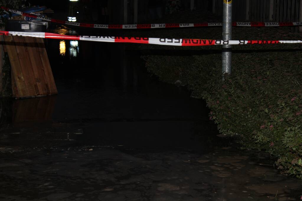 Groot sinkhole en straat vol water na leidingbreuk