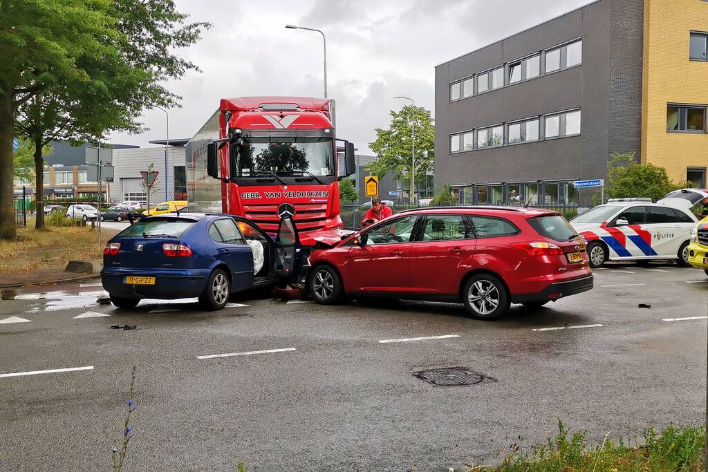 Vrachtwagen en auto's botsen op kruising