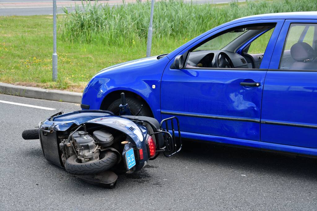Scooter botst op personenauto op busbaan
