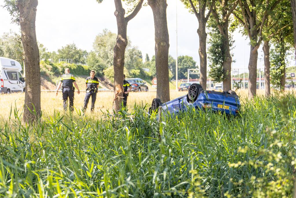 Auto raakt van snelweg en belandt op de kop