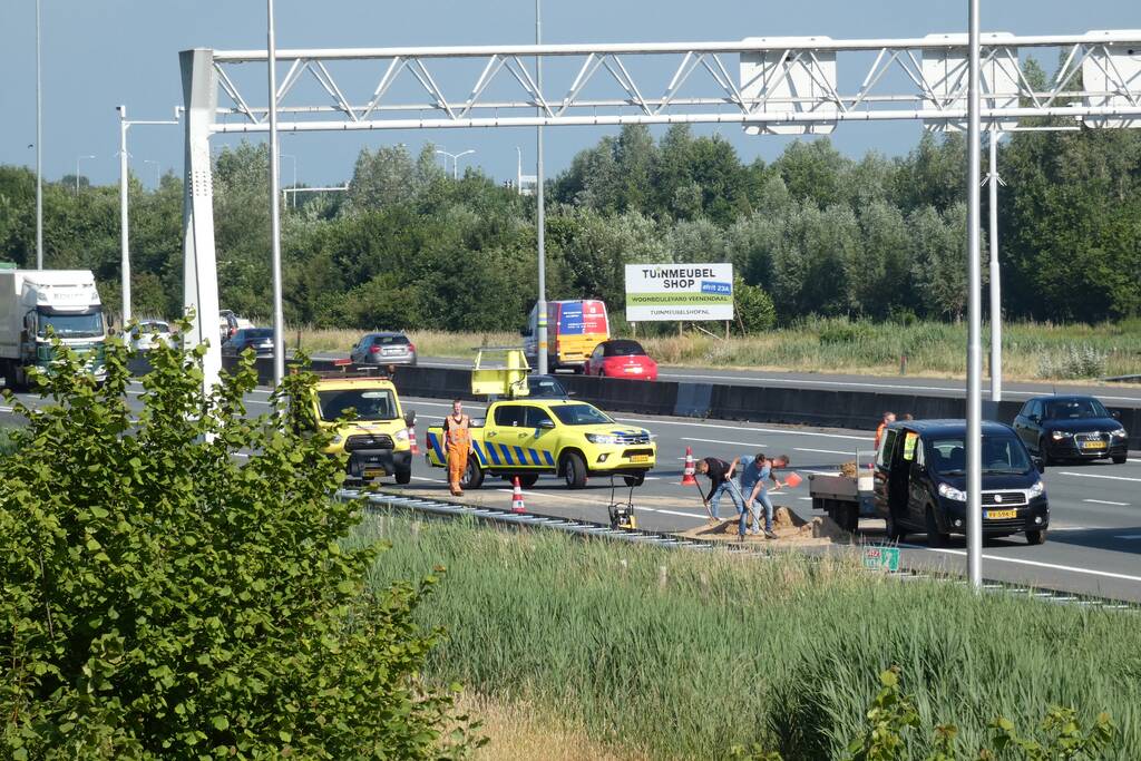 Aanhanger met zand slaat over de kop