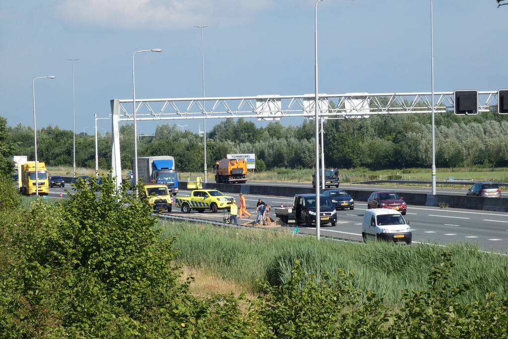 Aanhanger met zand slaat over de kop