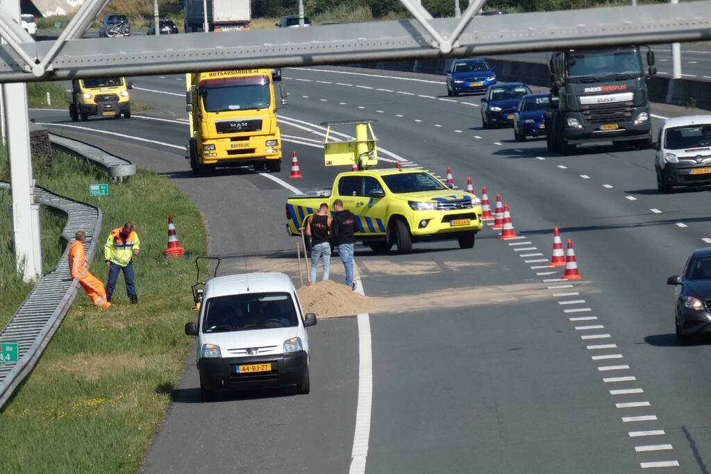 Aanhanger met zand slaat over de kop