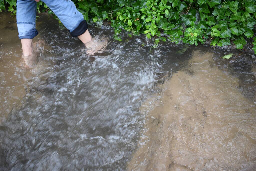 Straten en tuinen onder water door gesprongen leiding