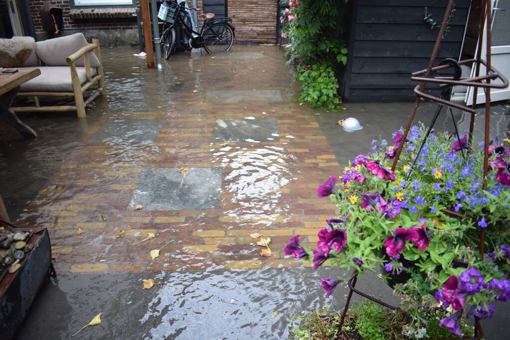 Straten en tuinen onder water door gesprongen leiding