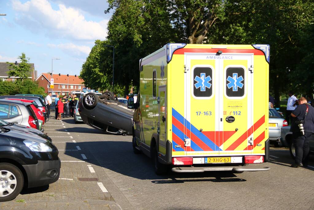 Auto op zijn kop na aanrijding met geparkeerde auto