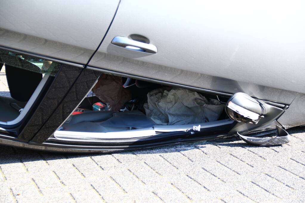 Auto op zijn kop na aanrijding met geparkeerde auto