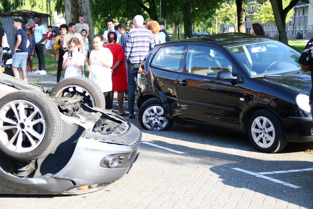 Auto op zijn kop na aanrijding met geparkeerde auto