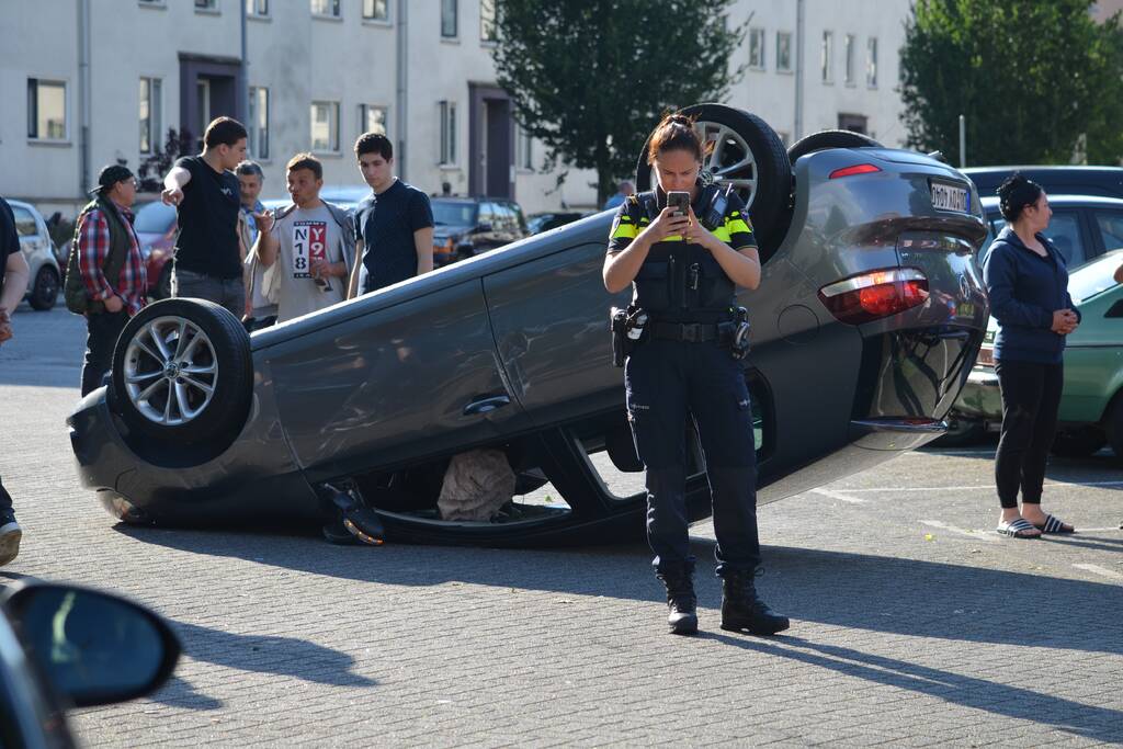 Auto op zijn kop na aanrijding met geparkeerde auto