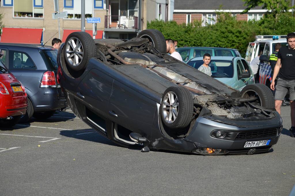 Auto op zijn kop na aanrijding met geparkeerde auto