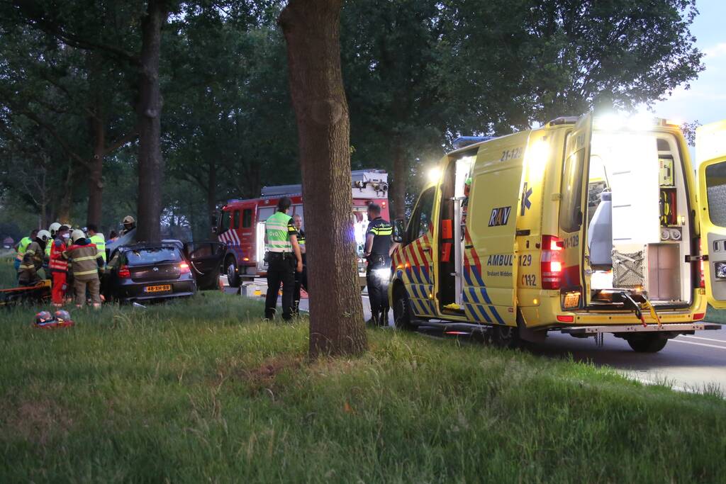 Bestuurder bekneld bij botsing tegen boom