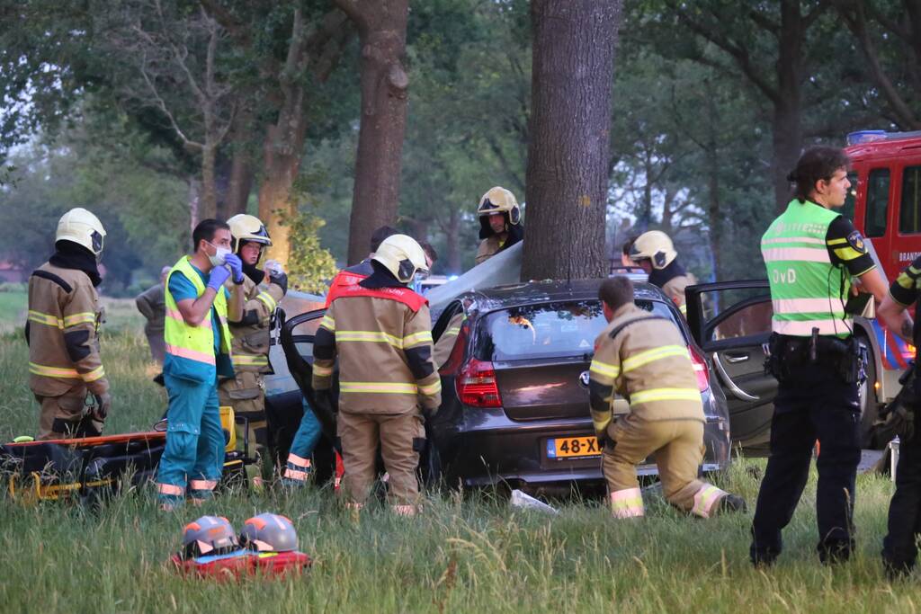 Bestuurder bekneld bij botsing tegen boom