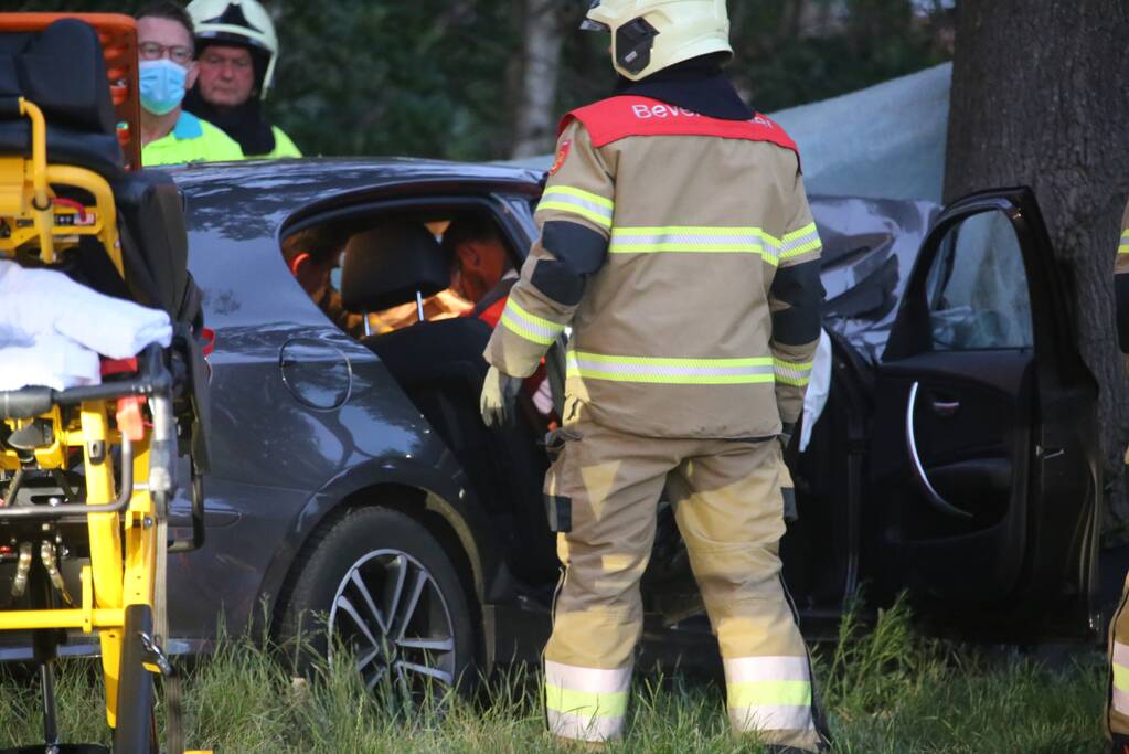 Bestuurder bekneld bij botsing tegen boom