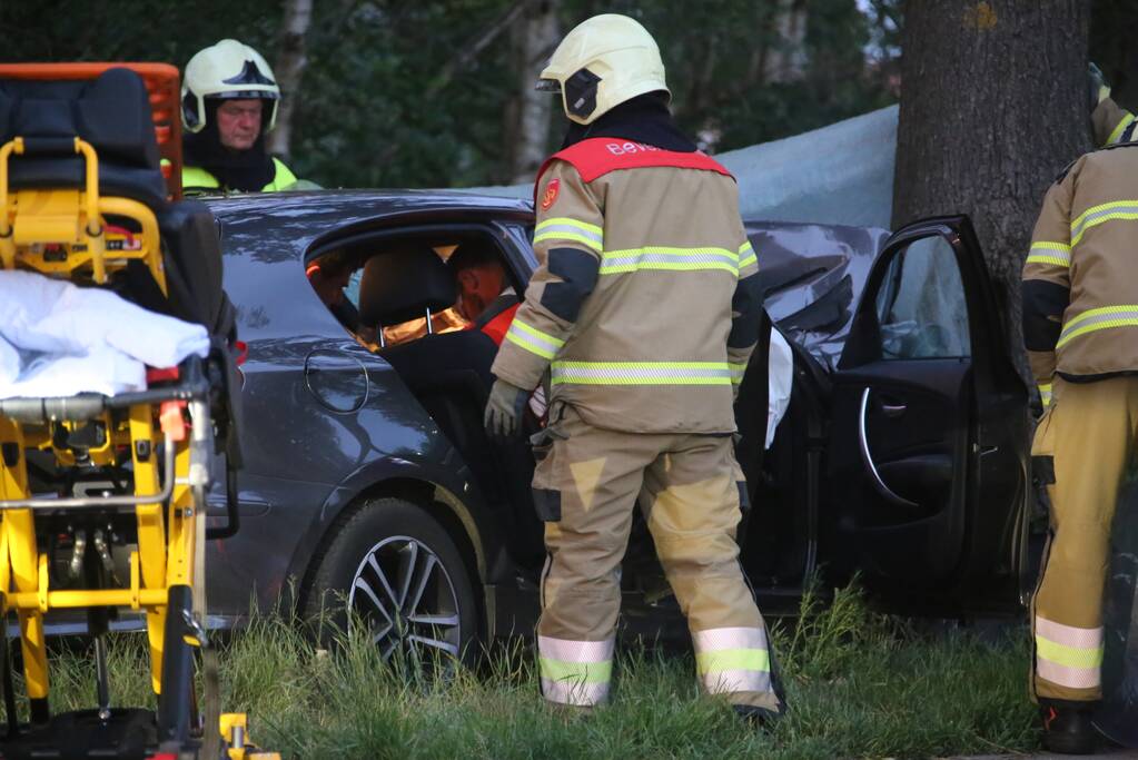 Bestuurder bekneld bij botsing tegen boom