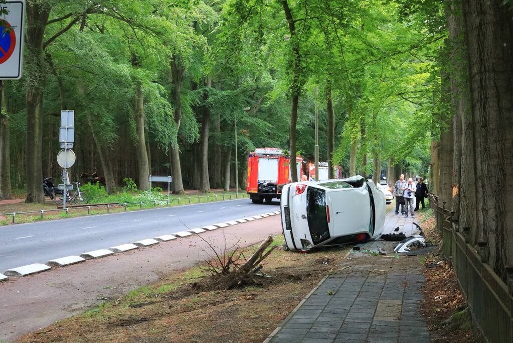 Auto crasht belandt op zijkant, bestuurder slaat op de vlucht